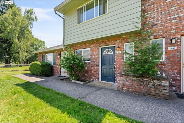 2062 NE Hogan Dr, Gresham, OR 97030 - view of exterior entry featuring a yard and brick siding