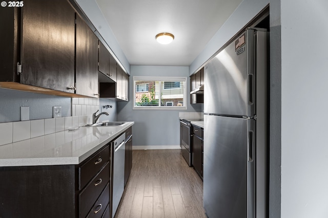 2062 NE Hogan Dr, Gresham, OR 97030 - kitchen featuring stainless steel appliances, under cabinet range hood, light wood-style flooring, light countertops, and dark brown cabinets