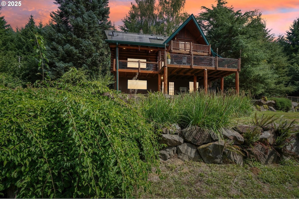 back house at dusk featuring a deck