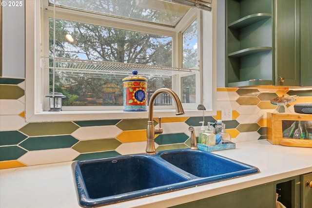 kitchen with tasteful backsplash, sink, and green cabinetry