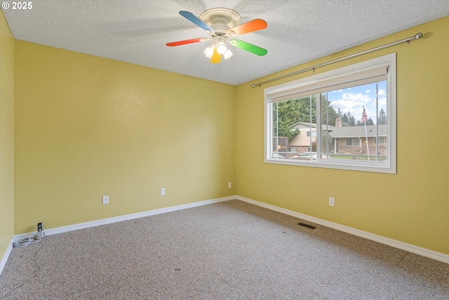 carpeted empty room with ceiling fan and a textured ceiling