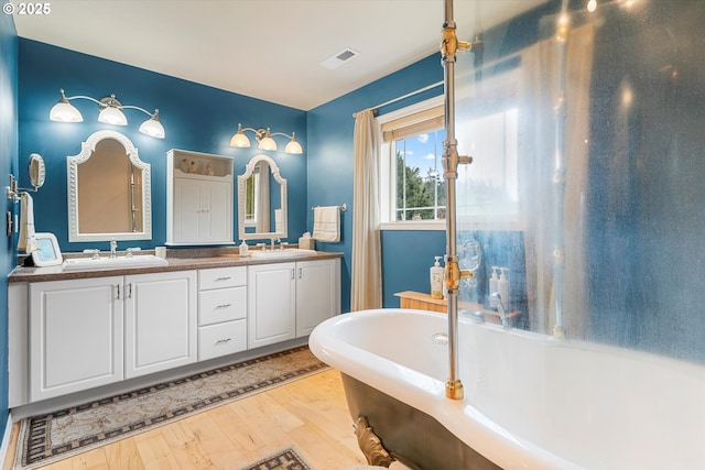 bathroom featuring hardwood / wood-style flooring, vanity, and a tub