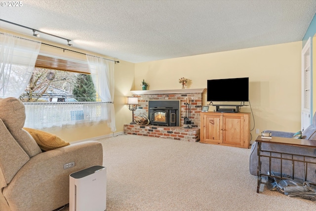 living room featuring rail lighting, a wood stove, carpet, and a textured ceiling