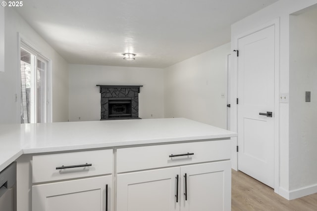 2817 Applewood Ln, Eugene, OR 97408 - kitchen with light wood-style flooring, white cabinets, light countertops, a fireplace, and a peninsula