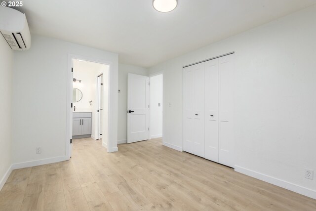 2817 Applewood Ln, Eugene, OR 97408 - unfurnished bedroom featuring a wall mounted air conditioner, light wood-style floors, a closet, and ensuite bathroom