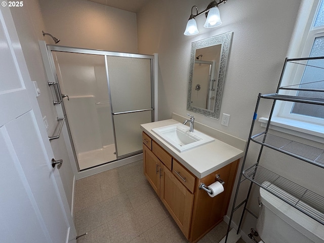 bathroom with toilet, a shower with door, and vanity