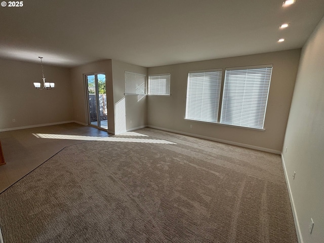 unfurnished living room featuring carpet floors and a notable chandelier