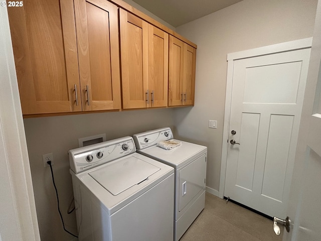 washroom with washing machine and dryer and cabinets