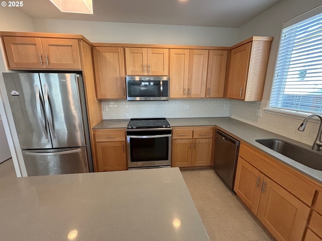 kitchen featuring appliances with stainless steel finishes, tasteful backsplash, and sink