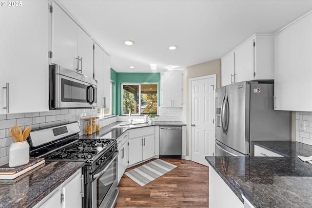 6902 SW Taylors Ferry Rd, Portland, OR 97223 - kitchen with appliances with stainless steel finishes, dark wood-type flooring, backsplash, white cabinets, and recessed lighting