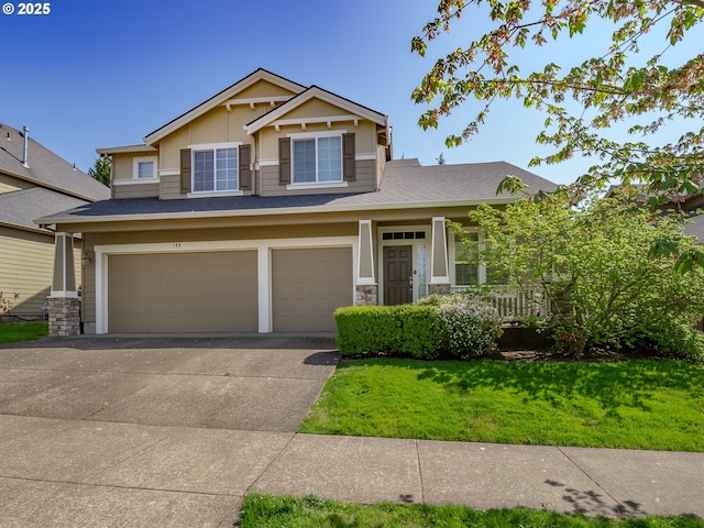 180 N The Greens Ave, Newberg, OR 97132 - craftsman house featuring an attached garage, concrete driveway, a front yard, stone siding, and roof with shingles