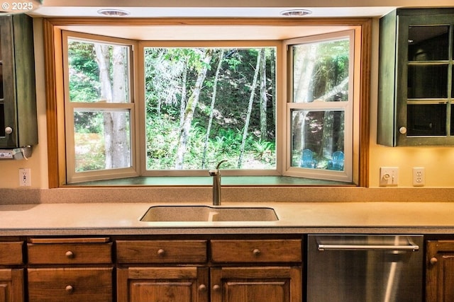 kitchen with dishwasher, a sink, and light countertops
