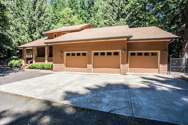 view of front of house featuring concrete driveway, a garage, a shingled roof, and covered porch
