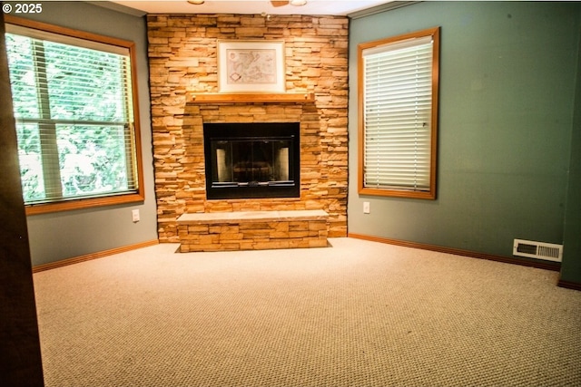 unfurnished living room with carpet flooring, plenty of natural light, baseboards, and crown molding