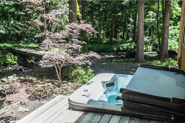 wooden deck featuring a covered hot tub