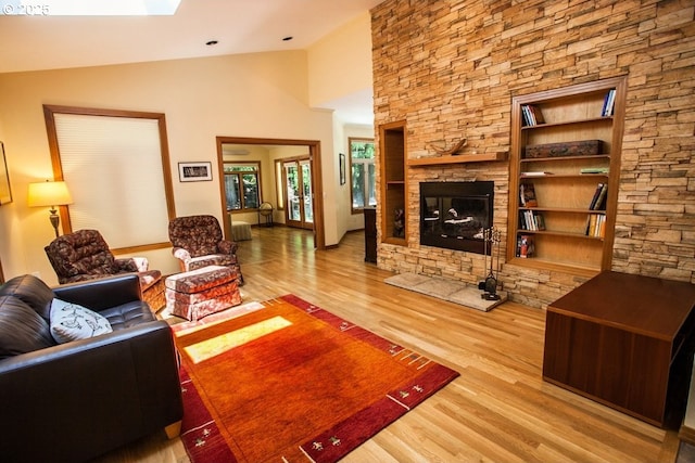 living room featuring wood finished floors, vaulted ceiling, and a fireplace