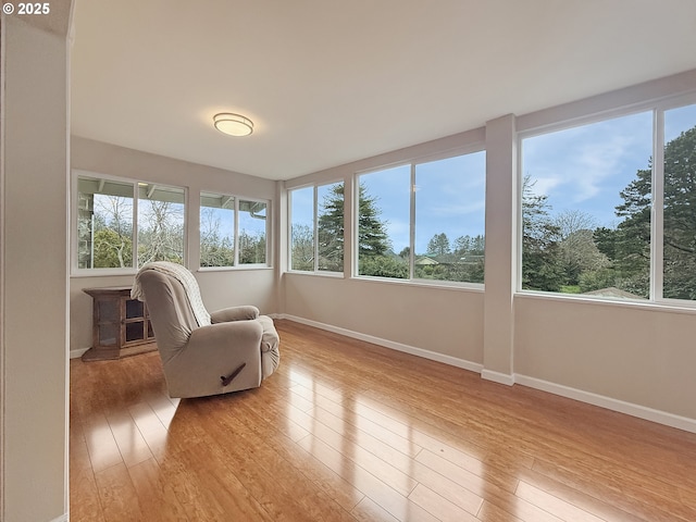 sitting room with plenty of natural light, baseboards, and light wood-style floors