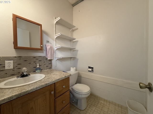 half bathroom featuring vanity, toilet, and a wainscoted wall