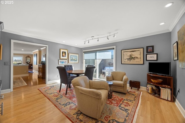 living room featuring baseboards, crown molding, and light wood finished floors