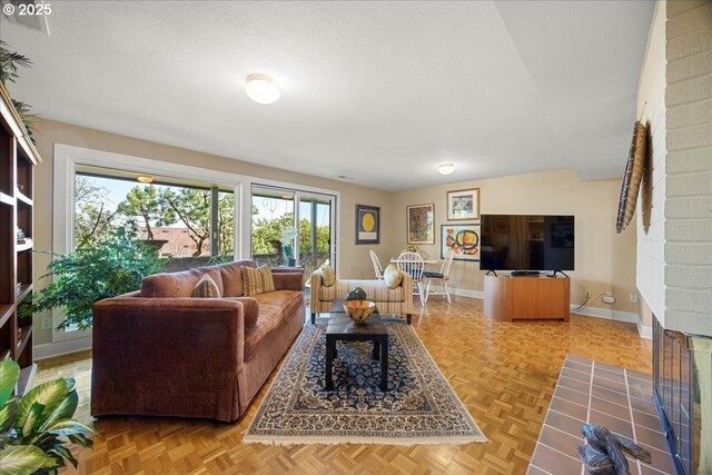 living area featuring a textured ceiling and baseboards