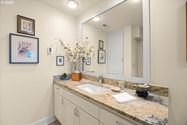 bathroom with vanity, baseboards, and visible vents