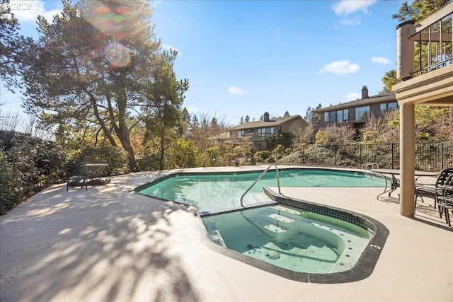 view of swimming pool with an in ground hot tub, a fenced in pool, a patio area, and fence