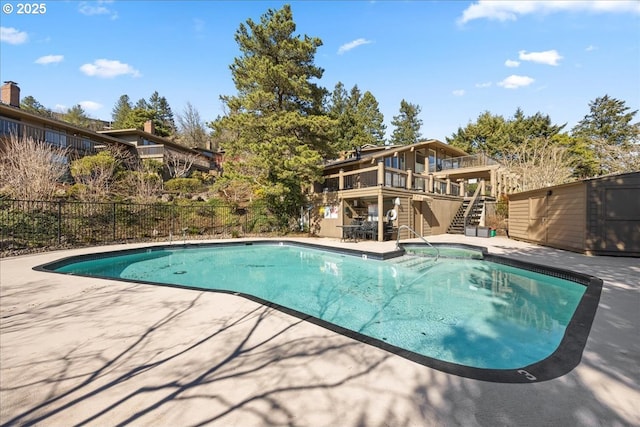 view of pool featuring a patio, fence, a wooden deck, a fenced in pool, and stairs