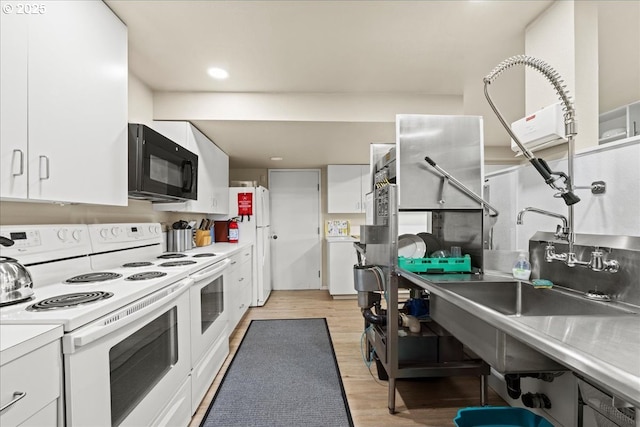 kitchen with white cabinetry, white appliances, light wood-style flooring, and light countertops