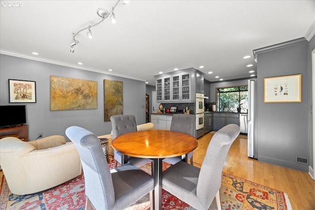 dining room featuring recessed lighting, light wood-type flooring, and ornamental molding