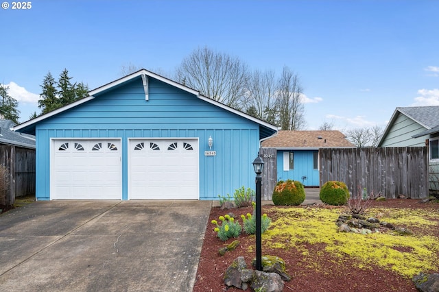 view of front of home with board and batten siding, fence, and a garage