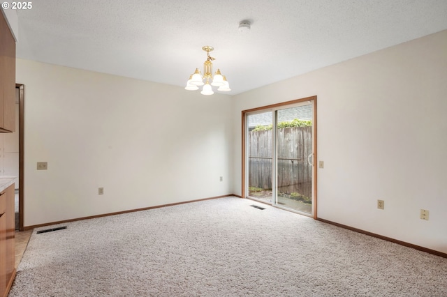 unfurnished room with visible vents, baseboards, light colored carpet, and an inviting chandelier