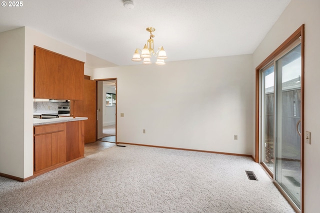 kitchen with light carpet, visible vents, backsplash, and brown cabinets