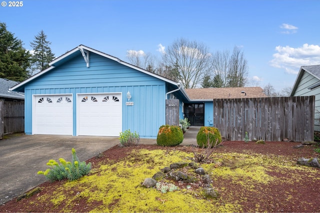 view of front of home featuring concrete driveway, an attached garage, fence, and board and batten siding