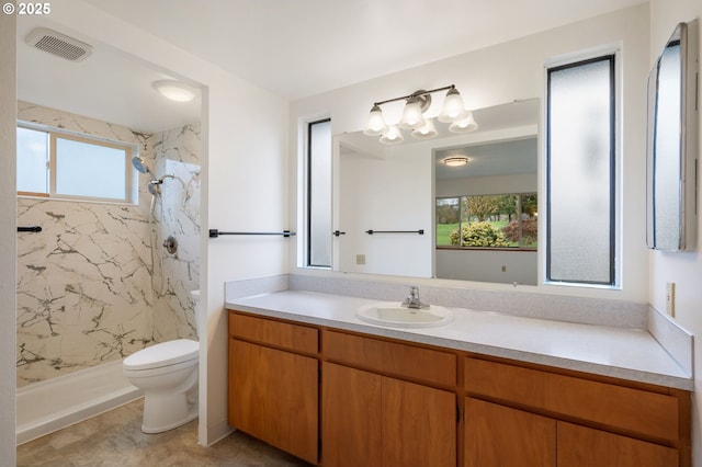 bathroom with a marble finish shower, visible vents, toilet, and vanity