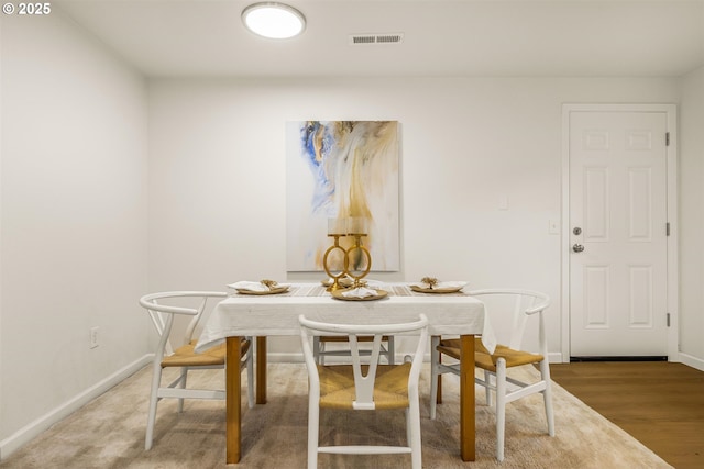 dining room featuring light wood-type flooring, baseboards, and visible vents