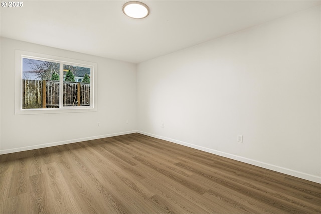 unfurnished room featuring baseboards and wood finished floors