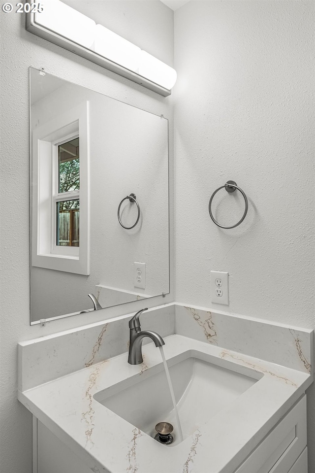 bathroom featuring a textured wall and vanity