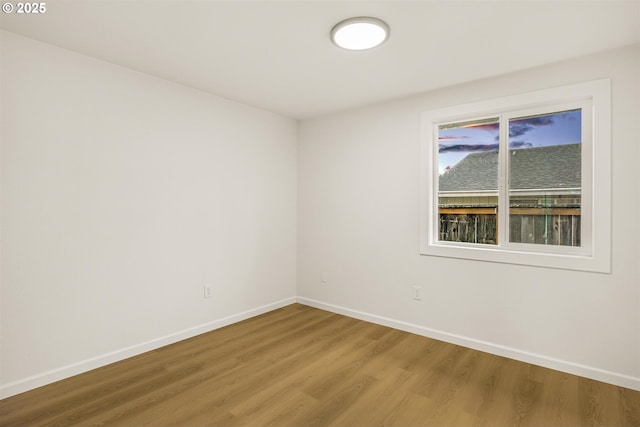 spare room with light wood-style flooring and baseboards