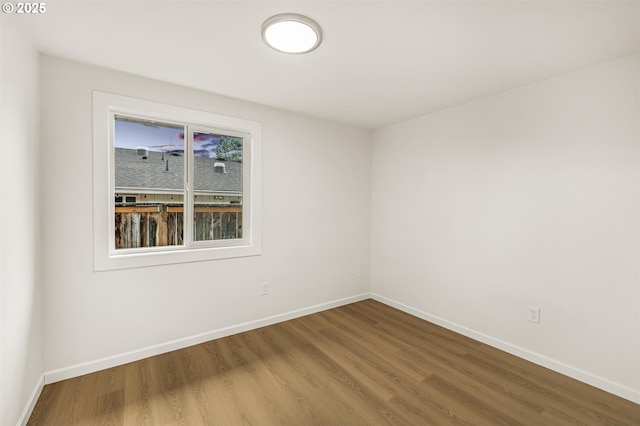 unfurnished room with baseboards and wood finished floors