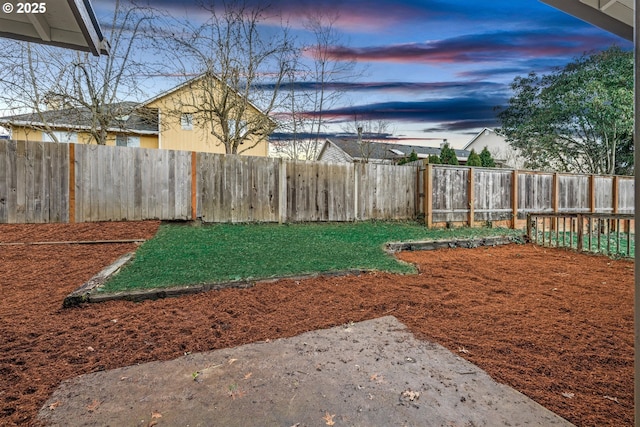 yard at dusk with a fenced backyard