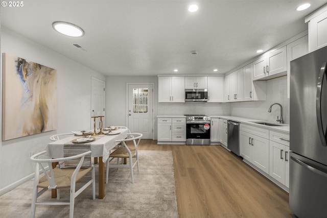 kitchen featuring a sink, visible vents, white cabinets, light countertops, and appliances with stainless steel finishes