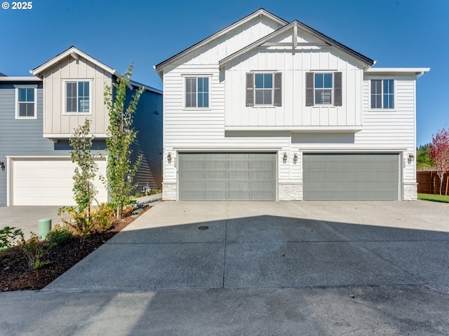 702 NW 178th Way, Ridgefield, WA 98642 - view of front of house featuring a garage, board and batten siding, concrete driveway, and stone siding