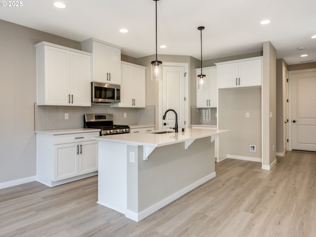 702 NW 178th Way, Ridgefield, WA 98642 - kitchen featuring stainless steel appliances, a sink, baseboards, light wood-style flooring, and recessed lighting
