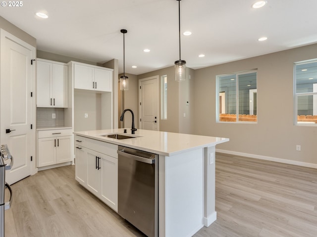 702 NW 178th Way, Ridgefield, WA 98642 - kitchen with dishwasher, a sink, light wood-style flooring, baseboards, and white cabinetry