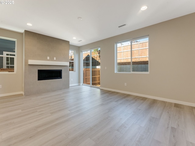 702 NW 178th Way, Ridgefield, WA 98642 - unfurnished living room featuring a fireplace, light wood-style flooring, baseboards, and recessed lighting