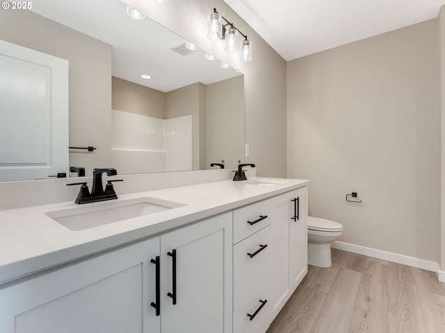 702 NW 178th Way, Ridgefield, WA 98642 - bathroom with wood finished floors, toilet, double vanity, baseboards, and a shower