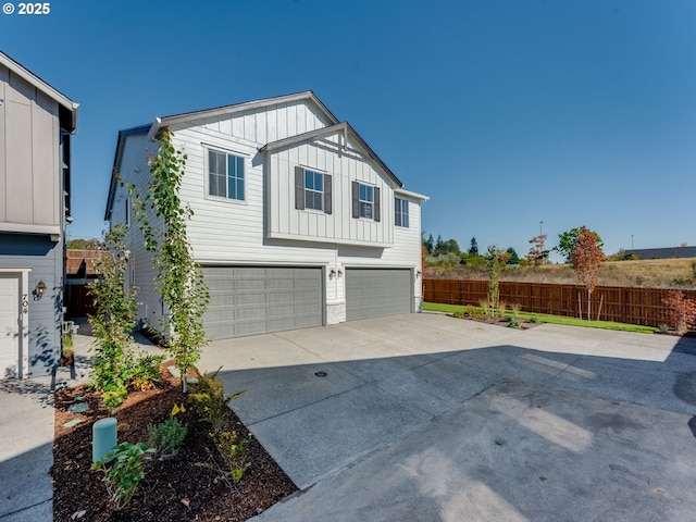 702 NW 178th Way, Ridgefield, WA 98642 - view of home's exterior featuring board and batten siding, driveway, a garage, and fence
