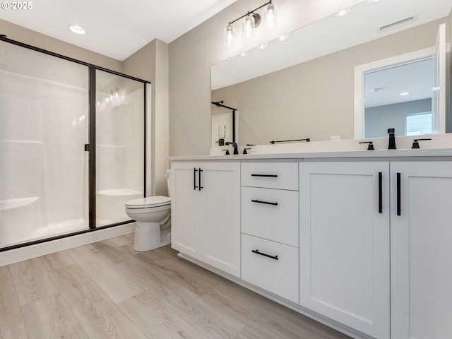 702 NW 178th Way, Ridgefield, WA 98642 - bathroom with toilet, a shower stall, wood finished floors, double vanity, and recessed lighting