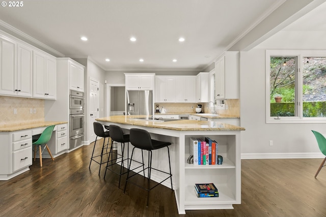 kitchen featuring an island with sink, dark hardwood / wood-style floors, light stone countertops, and white cabinets