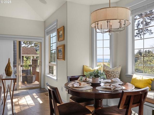 dining room featuring plenty of natural light, vaulted ceiling, a chandelier, and breakfast area